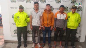 En la fotografía aparecen los tres capturados junto a dos agentes de la Policía Nacional. En la parte superior está un banner de la Policía Nacional