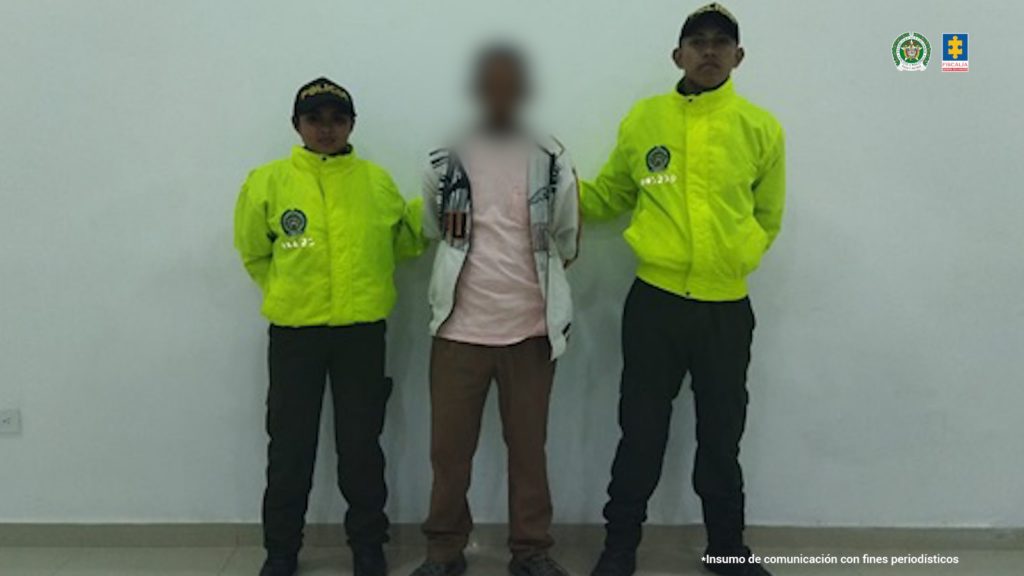 En la imagen aparece un hombre en medio de dos uniformados de la Policía.