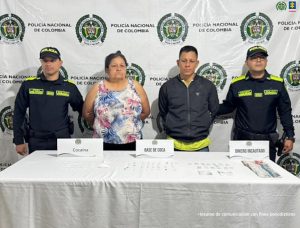 En la foto aparece los dos capturados de frente y custodiados por dos uniformados de la Policía Nacional. En la foto también se observa una mesa con algunas dosis de estupefaciente y dinero incautado.