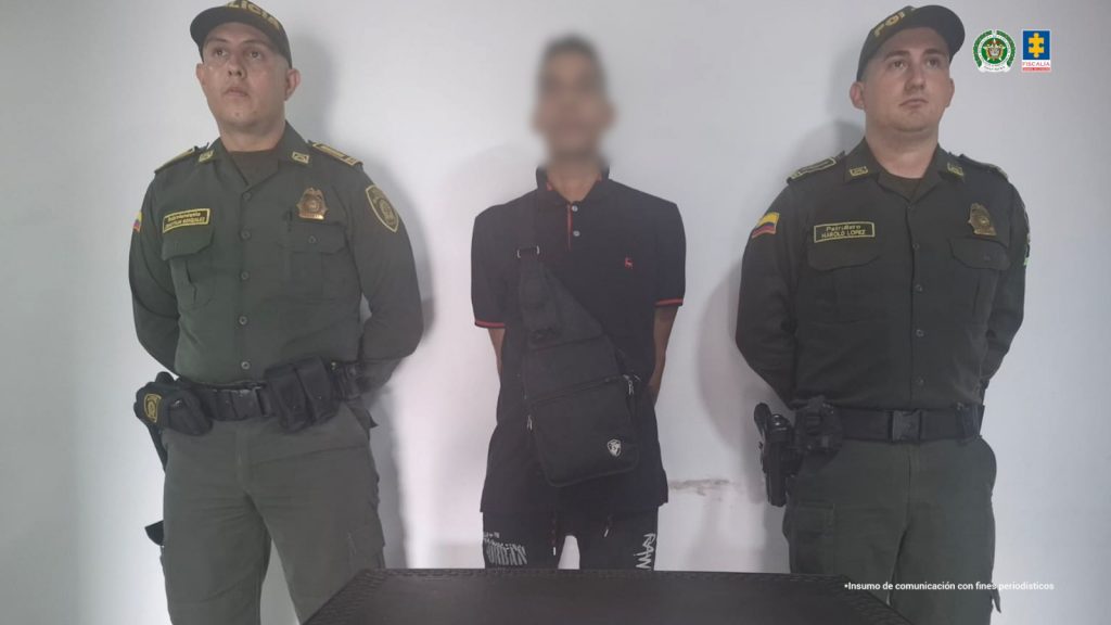 Se observa al capturado, de frente, custodiado a ambos costados por servidores de Policía Nacional. 