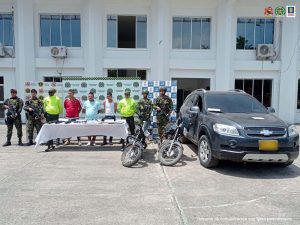 en la foto aparecen los tres asegurados siendo custodiados por miembros de la Policía y el Ejército Nacional.