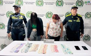 En la foto aparecen las dos capturadas de frente y custodiadas por dos uniformados de la Policía Nacional. En la foto aparece un backing de la Policía Nacional y una mesa con dinero y celulares (material incautado).