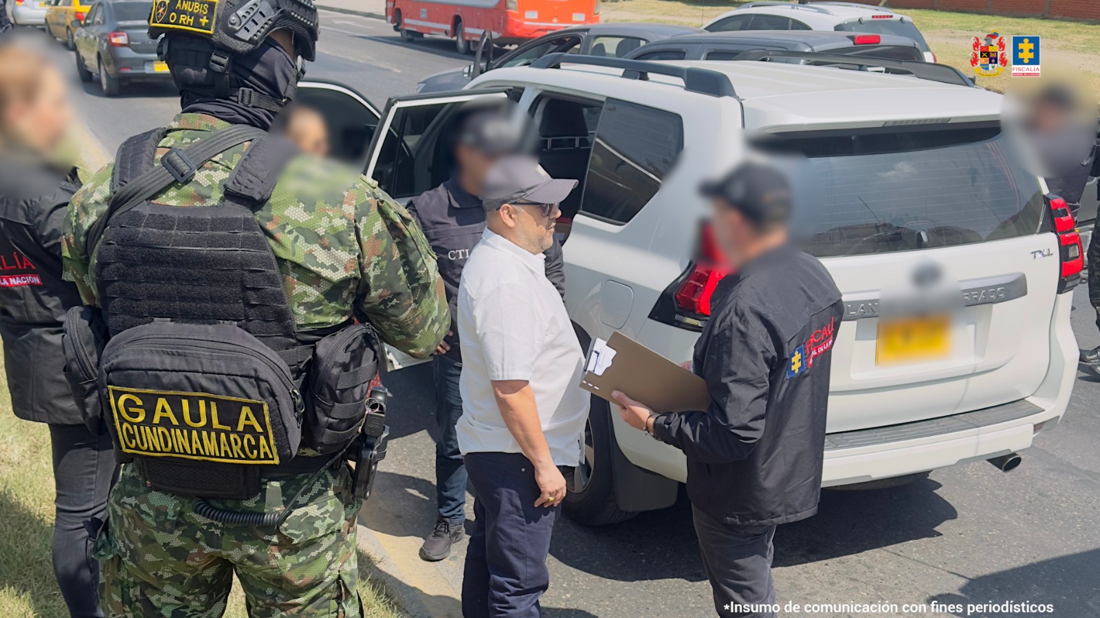 En la imagen se observa el momento en que uniformados del Ejército Nacional y servidores del CTI capturan a un hombre identificado como Néstor Julián Moreno Martínez. La detención ocurrió en una calle de la localidad de Fontibón. Varios soldados prestan seguridad mientras un funcionario del CTI le lee los derechos al capturado, quien viste una camisa blanca con pantalón azul. Al fondo se observa la camioneta blanca en la que el hombre viajaba con una mujer.