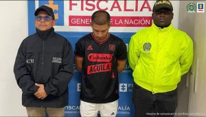 En la fotografía se aprecia de pie y con los brazos atrás a Carlos Alberto Arce Cifuentes. Viste camiseta de manga corta negra con estampados rojos; pantalón beage y zapatillas blancas. Al lado derecho de él hay un servidor del CTI de la Fiscalía y al lado izquierdo de él hay un uniformado de la Policía Nacional. Detrás de ellos hay un pendón institucional de la Fiscalía.