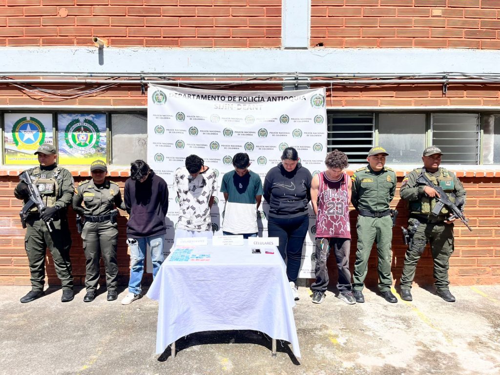En la imagen están los 5 procesados en medio de 4 servidores de la Policía Nacional.