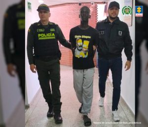 En la fotografía aparece en acción de caminata por un pasillo y con los brazos atrás Carlos Alberto Sinisterra Viáfara. Viste camiseta negra de manga corta con estampado de dibujos animados en color amarillo. Al lado izquierdo de él hay un servidor del CTI de la Fiscalía y al lado derecho un uniformado de la Policía Nacional.