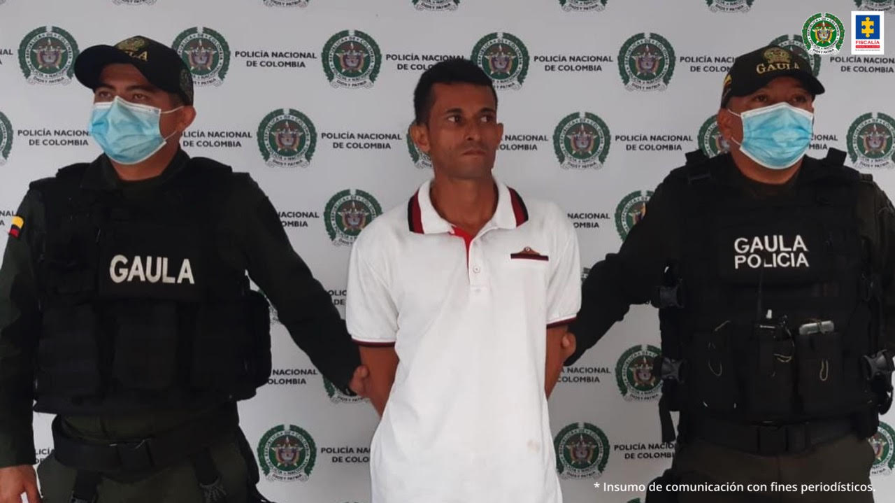 En la imagen se  ve una persona capturada en medio de dos uniformados. 