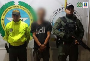 En la fotografía se observa al capturado junto a dos uniformados de la Policía Nacional. En la parte posterior se ubicó el banner que identifica a la Policía Nacional
