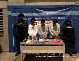 En la imagen están los 3 procesados con dos servidores del CTI y una mesa con el estupefaciente incautado.