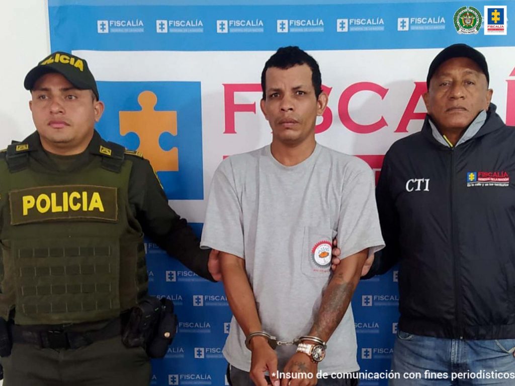 En la fotografía aparece un hombre capturado, junto a un servidor del CTI y un uniformado de la Policía Nacional, en la parte posterior un banner de la Fiscalía General del Nación.