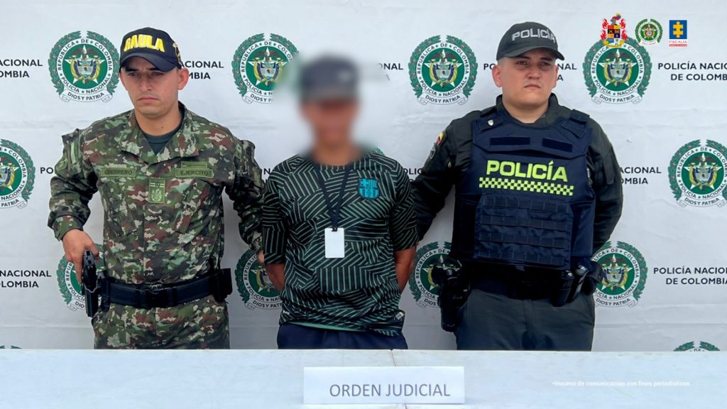 En la foto aparece el capturado custodiado por un uniformado del Gaula Militar y de la Policía Nacional. En la foto también aparece de fondo un backing de la Policía Nacional.