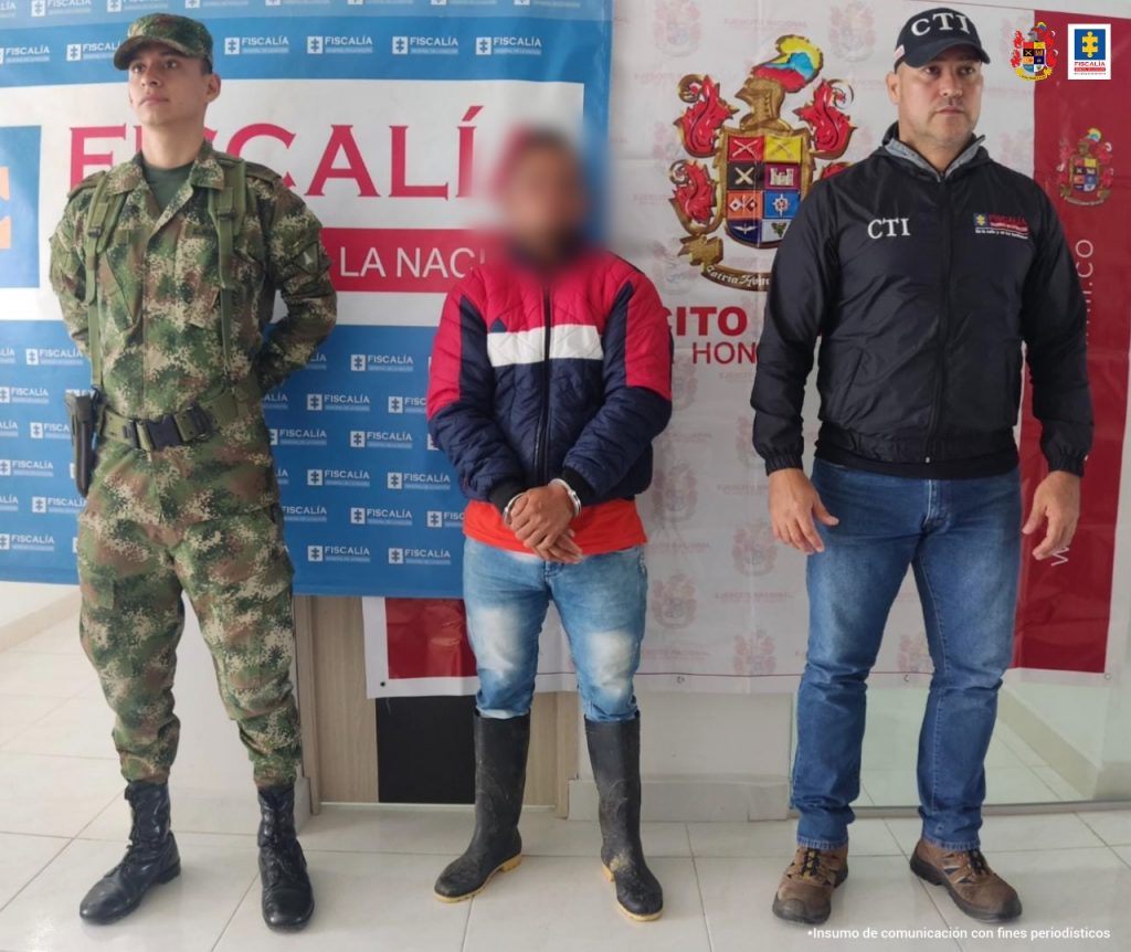 En las fotografía aparece un capturado, junto a personal de CTI y Ejército Nacional. En la parte posterior de la imagen se ven banners de Ejército Nacional y la Fiscalía General de la Nación.