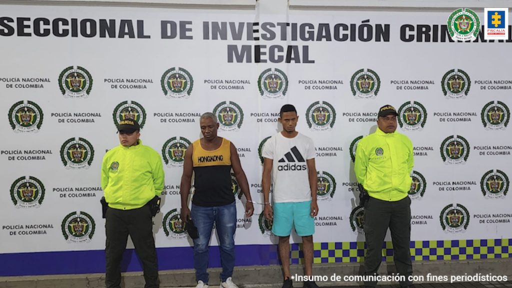 En la foto aparecen, de pie Juan Francisco Zapata Rivera y Michel Andrés Betancourt Grueso. Uno de ellos viste camiseta esqueleto amarilla en la parte superior y negro en la parte inferior; jean azul y tenis blancos. La otra persona vista camiseta de manga corta blanca con estampado negro a la altura del pecho; pantaloneta color aguamarina y tenis negros con naranja. A lado y lado de ellos hay uniformados de la Policía Nacional. Detrás de ellos hay un pendón institucional de la Policía Nacional.