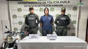 En la foto aparece el capturado custodiado por dos uniformados del Gaula de Policía Nacional. En la foto también aparece un backing de la Policía Nacional y la motocicleta