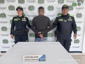 En la imagen aparece el procesado de espaldas, en medio de una pareja de servidores de la Policía Nacional. 