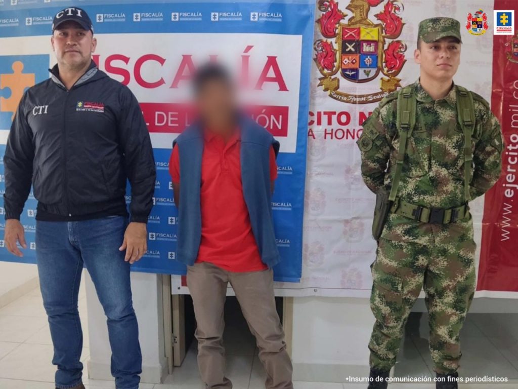 En las fotografía aparece un capturado, junto a personal de CTI y Ejército Nacional. En la parte posterior de la imagen se ven banners de Ejército Nacional y la Fiscalía General de la Nación.