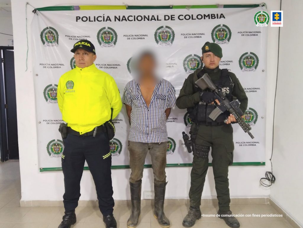 En la primera fotografía se observa a un capturado, masculino, y a cada costado, funcionarios de Policía Nacional. Atrás pendón de Policía Nacional