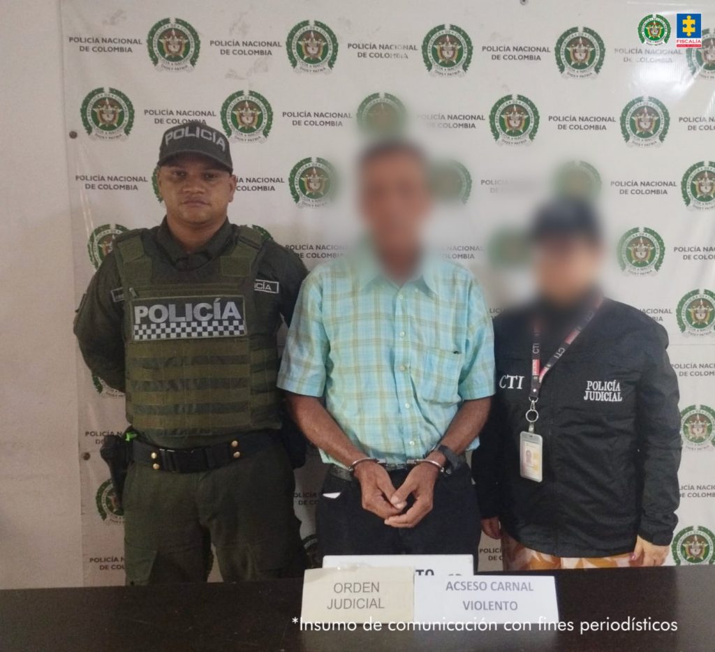 En la foto se ve al hombre capturado junto a un agente del CTI y la Policía. De fondo está el backing de la Policía Nacional.
