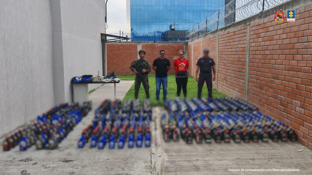 Los capturados se encuentran de frente y custodiados por un servidor del CTI y uniformados del Ejército Nacional. En la foto se observa en el suelo el material incautado.