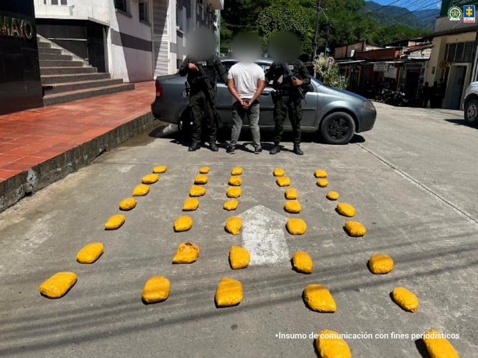 En la foto aparece el capturado de espalda y custodiado por uniformados de la Policía Nacional. En la foto también aparece el carro y los paquetes de pasta de base de coca incautados.