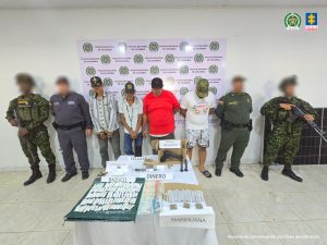 En la foto aparece todos los capturados de frente y custodiados por un servidor del Cuerpo Técnico de Investigación CTI, Policía y Ejército Nacional. En la foto también aparece parte de lo incautado durante las órdenes de allanamiento y registro.