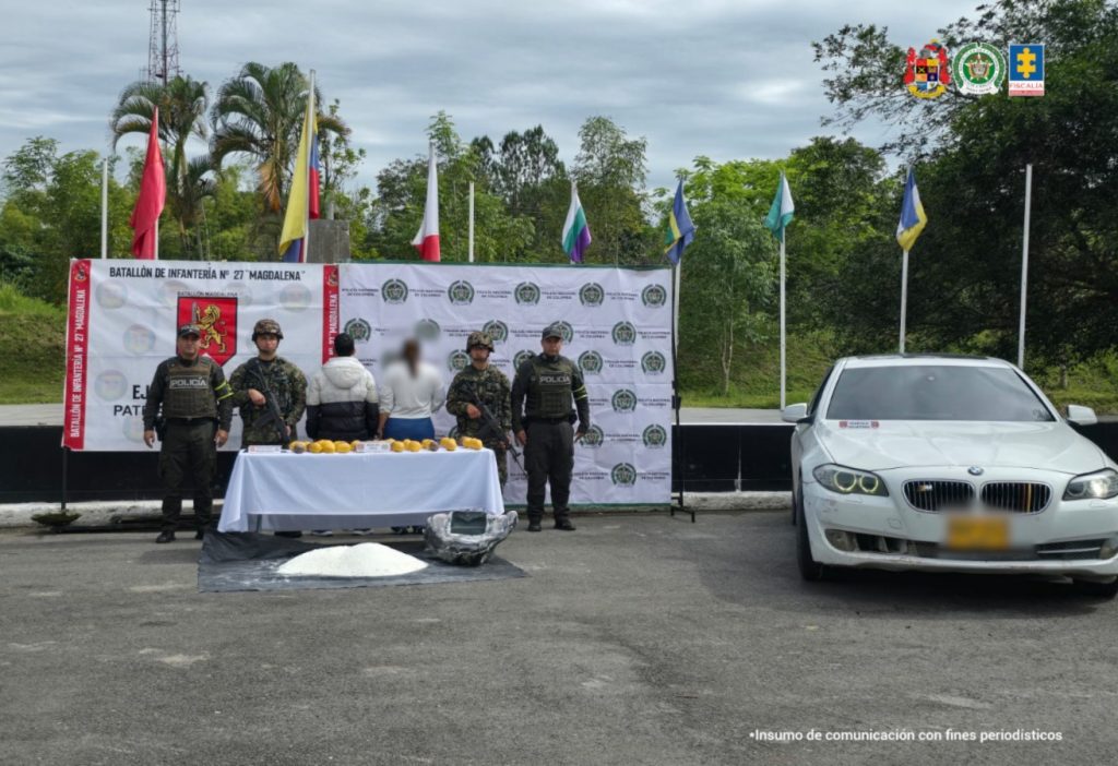 En la foto aparece el capturado de espaldas y custodiado por un uniformado del Ejército y también un uniformado de la Policía Nacional. En la foto también aparece de fondo un mural del batallón y se ve el cargamento de pasta de base de coca y el carro en el que presuntamente movilizaban la sustancia.