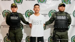En la foto aparece el capturado de frente y custodiado por dos uniformados de la Policía Nacional. En la foto también aparece un backing de la Policía Nacional.