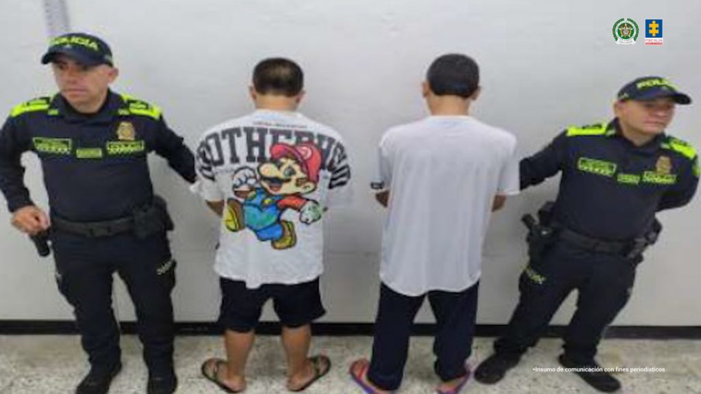 En las dos fotos aparecen cada uno de los procesados de espaldas y custodiados por uniformados de la Policía Nacional.