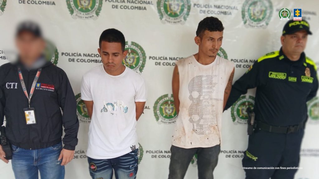 En la foto aparecen los capturados de frente y custodiado por un servidor del Cuerpo Técnico de Investigación CTI y un uniformado del Gaula de la Policía Nacional. En la foto aparece un backing de la Policía Nacional.