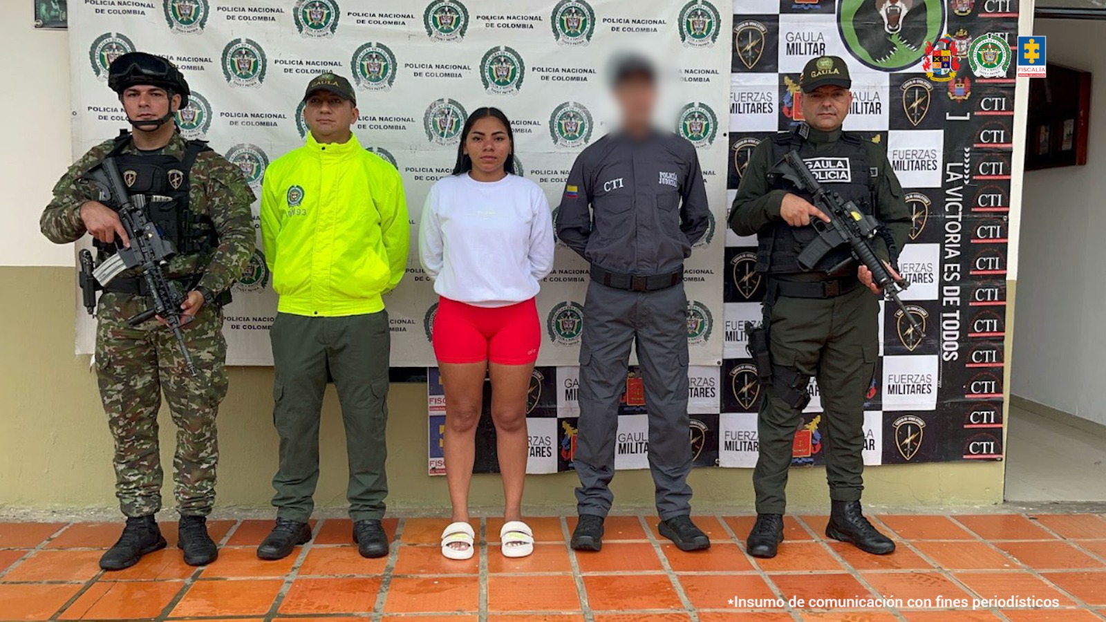 La capturada se encuentra de frente custodiada por un servidor del Cuerpo Técnico de Investigación CTI y uniformados del Gaula del Ejército y Policía Nacional. Detrás se observa el backing de la Policía y Ejército Nacional.