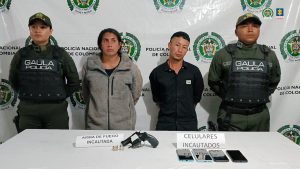 En la foto aparece los dos capturados de frente y custodiados por dos uniformados de la Policía Nacional. En la foto también aparece una mesa con los elementos que les incautaron durante el operativo de captura.