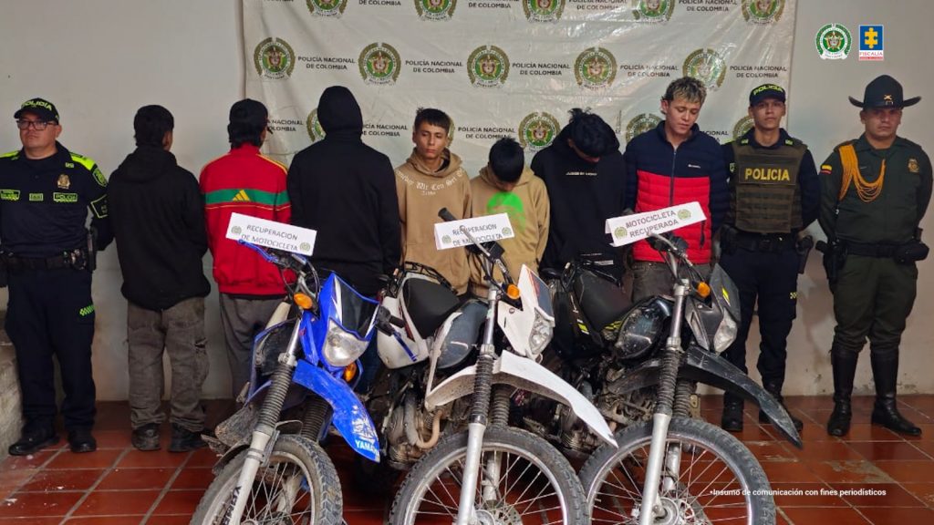 En la foto aparece los capturados custodiados por uniformados de la Policía Nacional.  En la foto también aparece las motocicletas en las que se movilizaban