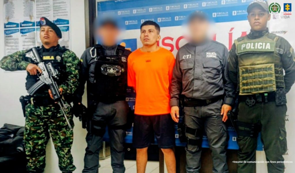 En la fotografía aparen el capturado junto a dos servidores del CTI, un uniformado de la Policía Nacional y un soldado del Gaula Militar. En la parte superior están un banner de la Fiscalía General.