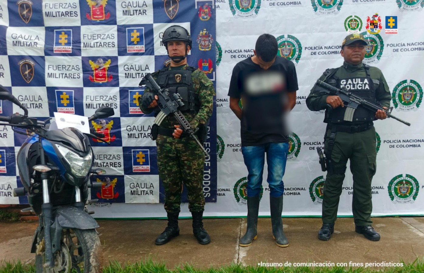 El capturado se encuentra de frente custodiado por uniformados del Gaula del Ejército y Policía Nacional. Detrás se observa el backing de la Policía y Ejército Nacional y se observa la mota incautada.