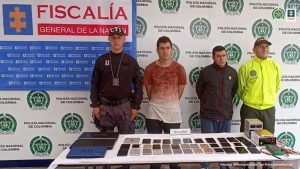 Se observan dos mujeres capturadas al centro. A un costado un funcionario del Cuerpo Técnico de Investigación CTI y al otro lado uno de la Policía Nacional. Atrás las banderas de la Fiscalía general de la Nación y la de ColombiaPIE DE FOTO: Lady Johanna Vargas Rojas y Diana Marcela Ruiz Rojas fueron privadas de la libertad