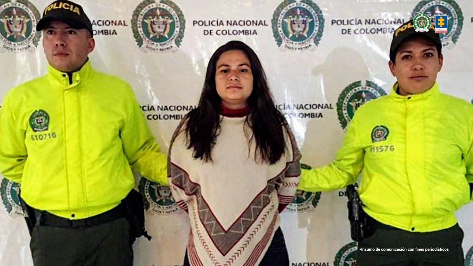 La mujer aparece en el centro de la imagen, con las manos esposadas en la espalda. De cada brazo la sostienen miembros de la Policía.