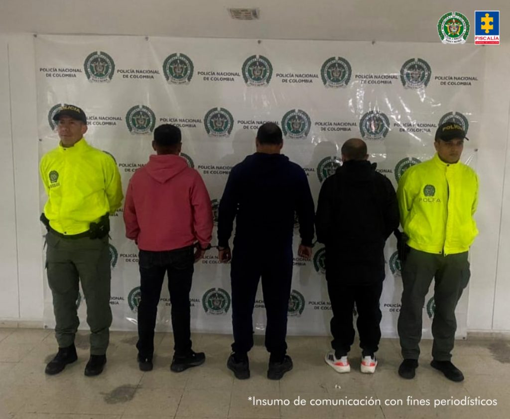 En la fotografía aparecen varios capturados junto a a agentes de la Policía Fiscal y Aduanera. En la parte superior esta un banner de la Policía Nacional