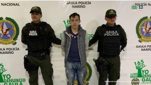 En la fotografía aparece el capturado junto a dos agentes del Gaula de la Policía Nacional. En la parte superior está un banner del Gaula de la Policía