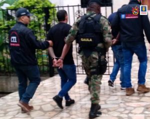 En la foto se aprecia a Cristian Andrés Millán Ramírez y José Luis Grueso Solís, en acción de caminata, con los brazos atrás, esposados y conducidos por personal uniformado del CTI de la Fiscalía y del Gaula Ejército.