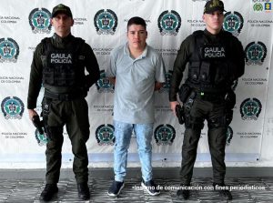 En la fotografía aparece de pie y con los brazos atrás Cristian Camilo García Palechor. Viste con camisa de cuello, mangas cortas, de color azul claro; jean azul y zapatillas azules con zuela blanca. A sus extremos hay uniformados de la Policía Nacional. Detrás de ellos hay un pendón institucional de la Policía.