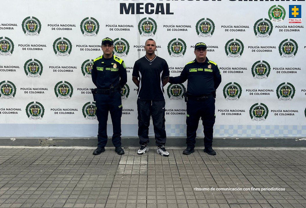 En la fotografía aparece de pie, con los brazos atrás Cristian David Orozco Gálviz. Presenta entradas pronunciadas en su cabello. Viste con camiseta de mangas cortas, de color negro, con ribete blanco en el cuello y franjas blancas a los lados del trozo; pantalón negro y zapatillas blancas con negro. A sus extremos hay uniformados de la Policía Nacional. Detrás de ellos hay un pendón institucional de la Policía.