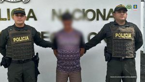 El procesado se encuentra esposado y en custodia por uniformados de la Policía Nacional.