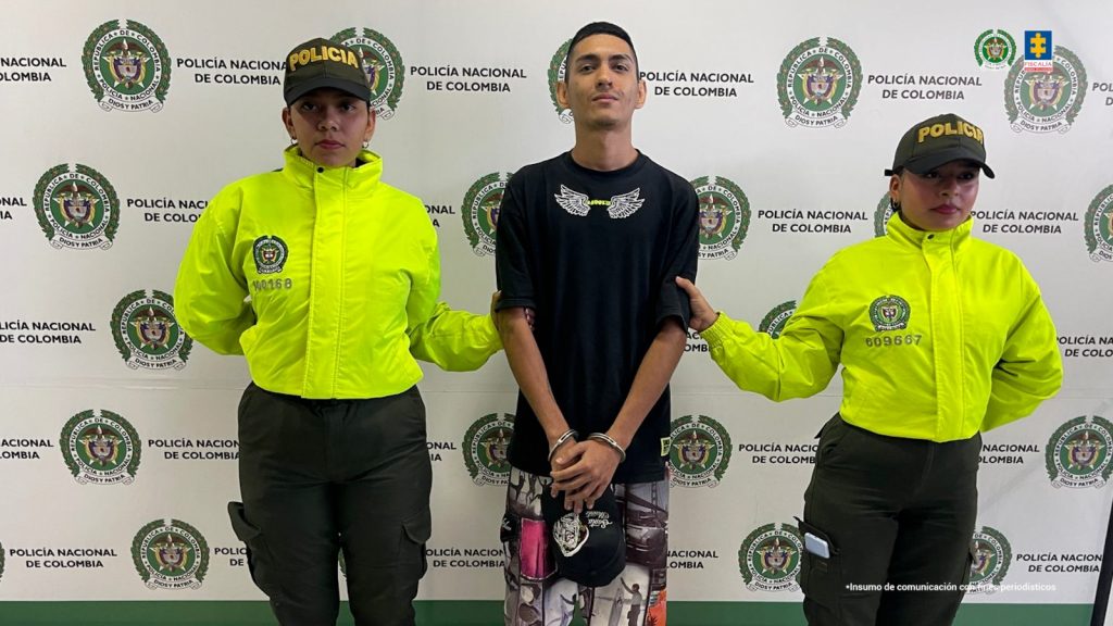 En las imágenes aparecen los capturados esposados y custodiados por uniformados de la Policía Nacional, de fondo aparecen pendones institucionales de la fuerza pública.