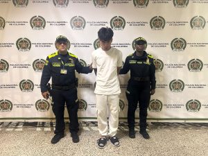 En la imagen está el procesado con dos servidores de la Policía Nacional