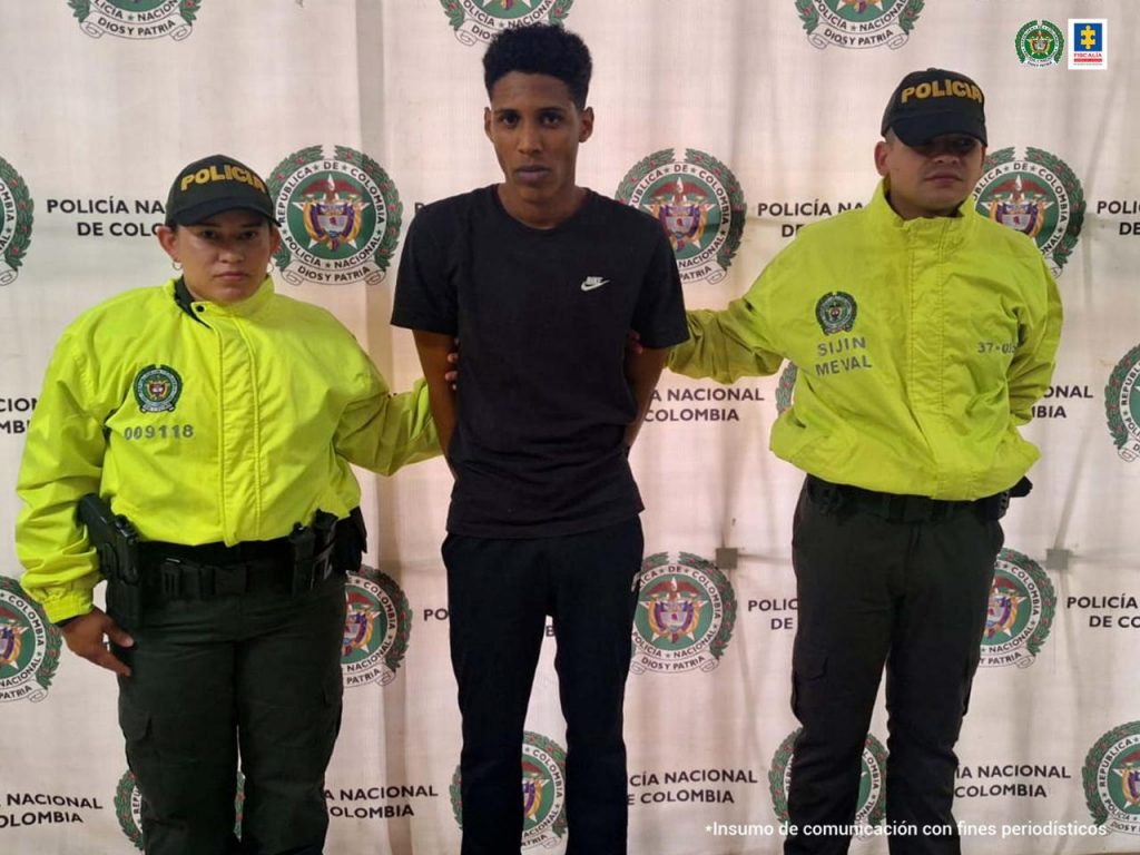 En la imagen está el presunto responsable del homicidio acompañado de dos servidores de la Policía Nacional, que usan chaqueta reflectiva color verde.