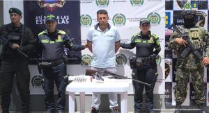 En la imagen se ven cuatro personas detenidas bajo custodia de la Policía Nacional. Detrás de ellos un backing institucional.
