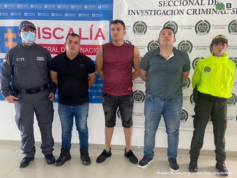 En la fotografía aparecen los tres capturados en medio de un investigador del CTI y de una uniformada de la Policía Nacional, detrás de ellos se aprecia los banners de la Fiscalía y de la Policía Nacional.