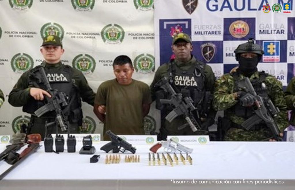 En la fotografía aparece de pie y con los brazos atrás Darwin Taicus Canticus. Viste con camiseta de manga corta, de color verde oliva. A sus extremos hay uniformados del Ejército y Policía Nacional. Delante de ellos hay una superficie blanca y sobre ella se aprecian armas de fuego, munición, radio de comunicaciones y un proveedor. Detrás de ellos hay dos pendones institucionales de la Policía y Gaula Militar.