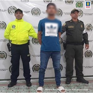 Dos uniformados de la Policía Nacional custodian al procesado (de camisa azul).