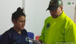 En la fotografía aparecen una mujer capturada, en compañia de un uniformados de la Policía Nacional